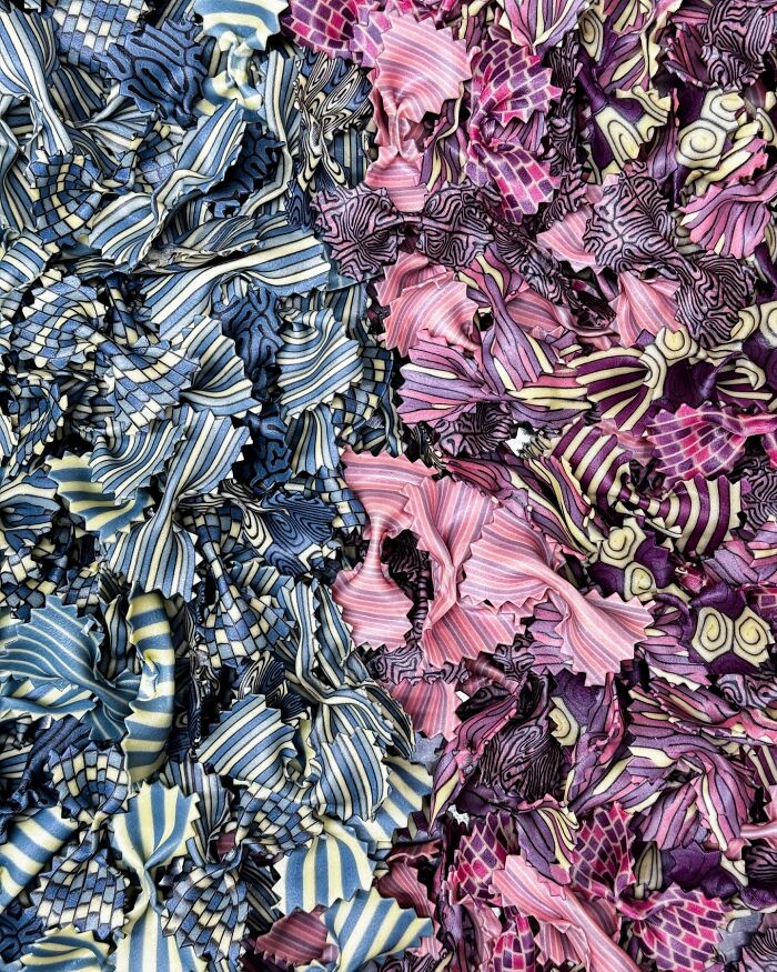 Colorful handcrafted pasta with intricate patterns, featuring vibrant stripes and swirls in blue and pink hues.