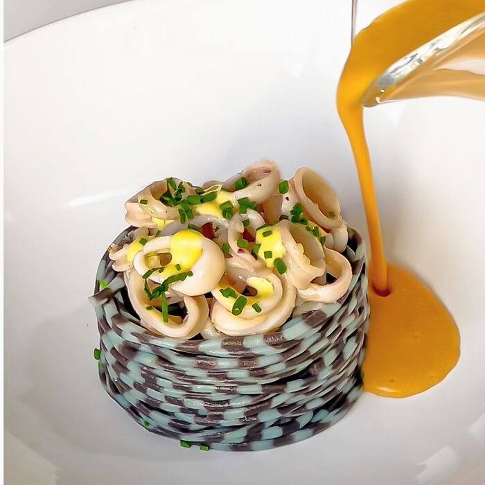 Artistic pasta dish with colorful sauce, highlighting a chef's creative culinary patterns and colors.