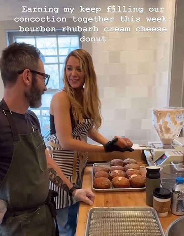 Person in apron with Blake Lively making donuts in a shop kitchen. Person in apron with Blake Lively making donuts in a shop kitchen.