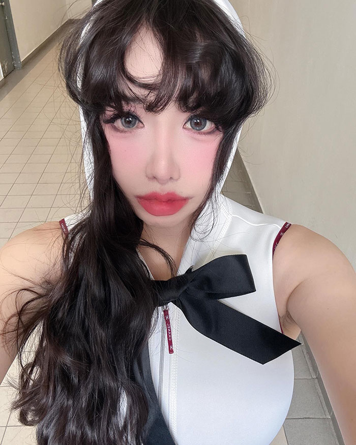 K-Pop star poses in a sleeveless outfit with long dark hair, amid plastic surgery rumors. K-Pop star poses in a sleeveless outfit with long dark hair, amid plastic surgery rumors.