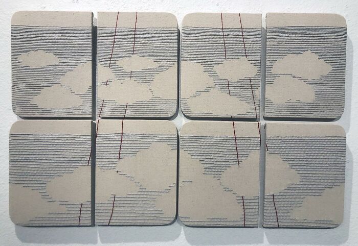 Fabric embroidered to resemble notebook pages with clouds.