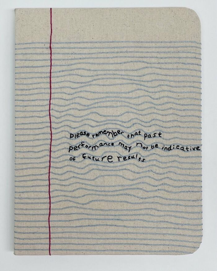 Fabric embroidered to resemble a notebook page with stitched text message.