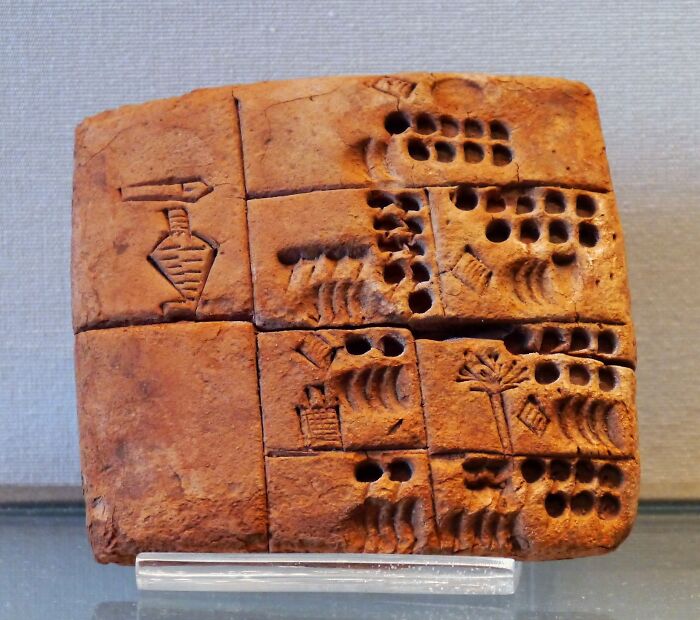 Ancient clay tablet featuring one of the oldest written texts with symbolic inscriptions and patterns.