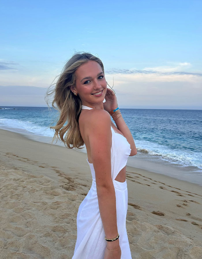 Young woman in a white dress posing on a beach at sunset. Young woman in a white dress posing on a beach at sunset.