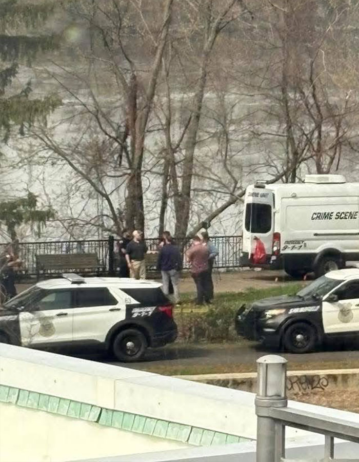 Crime scene investigation with police vehicles and officers near wooded area in New England. Crime scene investigation with police vehicles and officers near wooded area in New England.