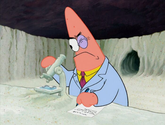 Animated character in a lab coat studying with a microscope, humorously highlighting how men are seen as a different species.