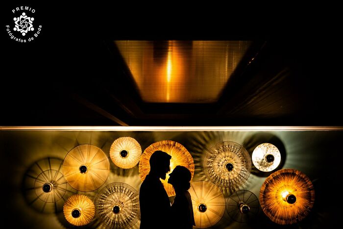 Silhouette of a couple against illuminated umbrellas, showcasing top wedding photography at the 2025 Premios FDB Awards.