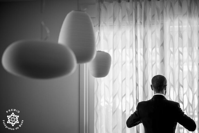 Elegant black-and-white wedding photo from the 2025 Premios FDB Awards, featuring a groom silhouetted by curtains.