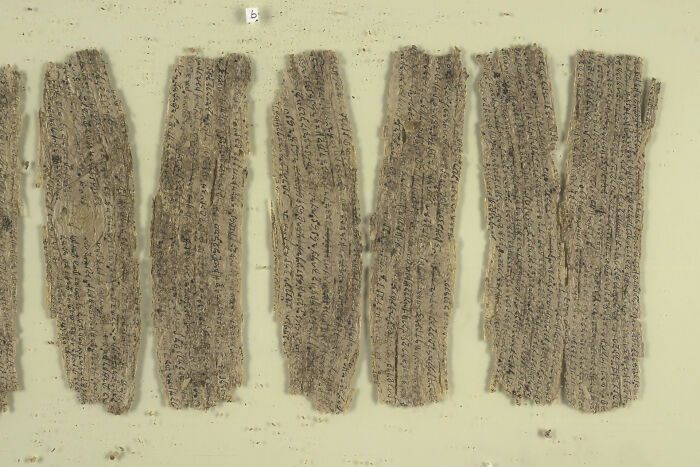 Ancient written text fragments with faded characters, showcasing some of the world’s oldest written text.