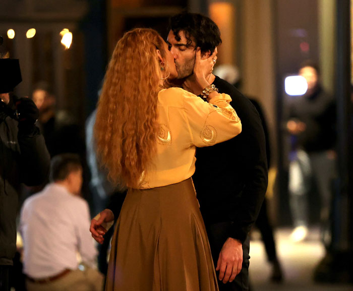 Blake Lively kisses a man in a dramatic moment during a filming scene outdoors. Blake Lively kisses a man in a dramatic moment during a filming scene outdoors.