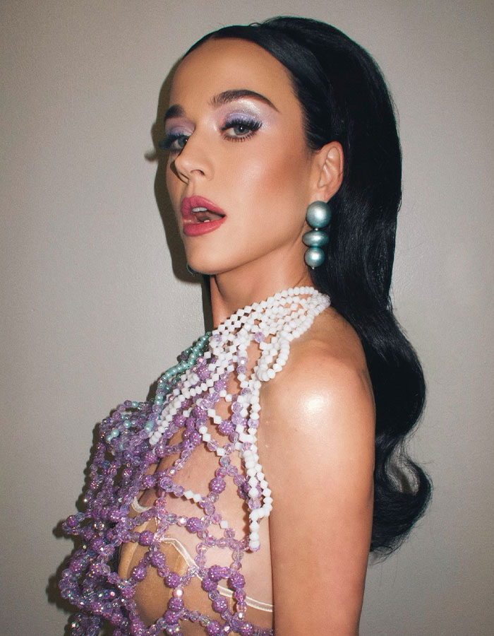 A woman with dark hair in an intricate beaded outfit, with Lauren Sanchez's space mission as a background context. A woman with dark hair in an intricate beaded outfit, with Lauren Sanchez's space mission as a background context.