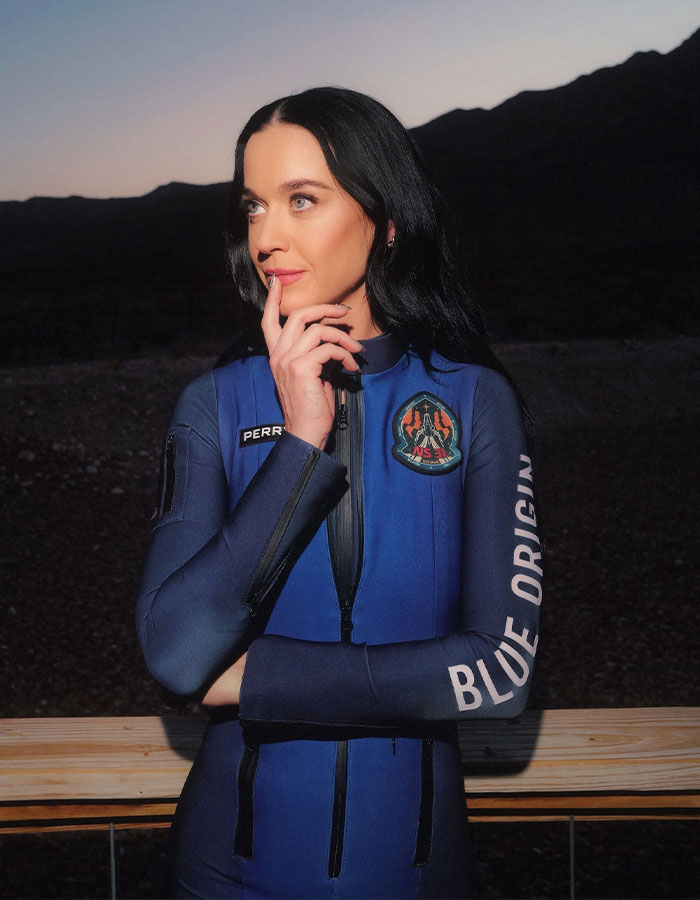 Person in a Blue Origin spacesuit, pondering under a dark sky, symbolizing space travel and Earth return. Person in a Blue Origin spacesuit, pondering under a dark sky, symbolizing space travel and Earth return.