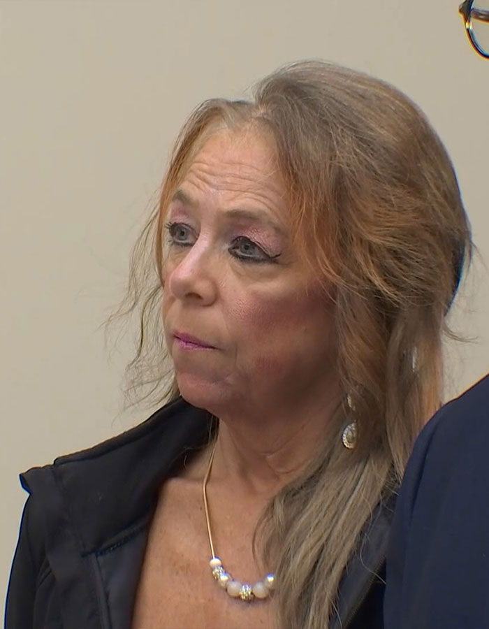 Woman involved in stepson case discusses her perspective, wearing a necklace and dark jacket. Woman involved in stepson case discusses her perspective, wearing a necklace and dark jacket.
