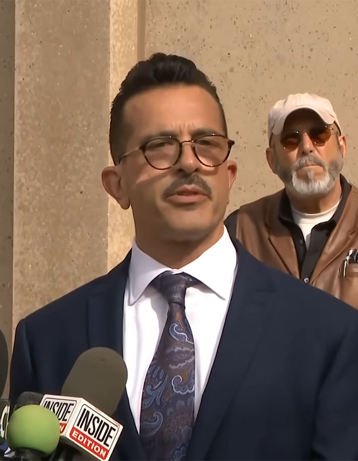 Man in a suit speaks at a press event, addressing a case about a woman who locked up her stepson for 20 years. Man in a suit speaks at a press event, addressing a case about a woman who locked up her stepson for 20 years.