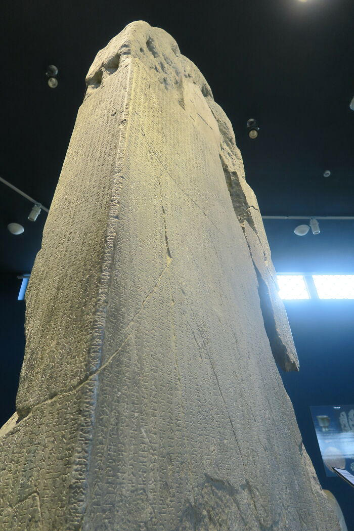 Ancient stone slab with inscriptions in a museum, showcasing one of the oldest written texts.