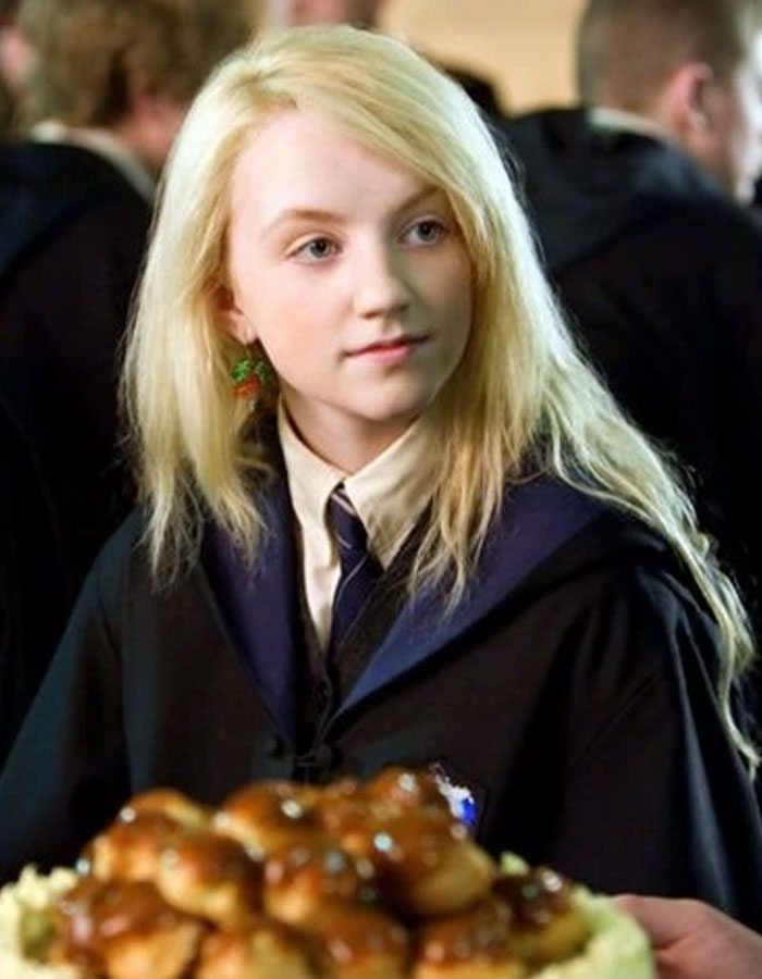 Harry Potter star in costume as Luna Lovegood, looking thoughtful at a feast scene. Harry Potter star in costume as Luna Lovegood, looking thoughtful at a feast scene.