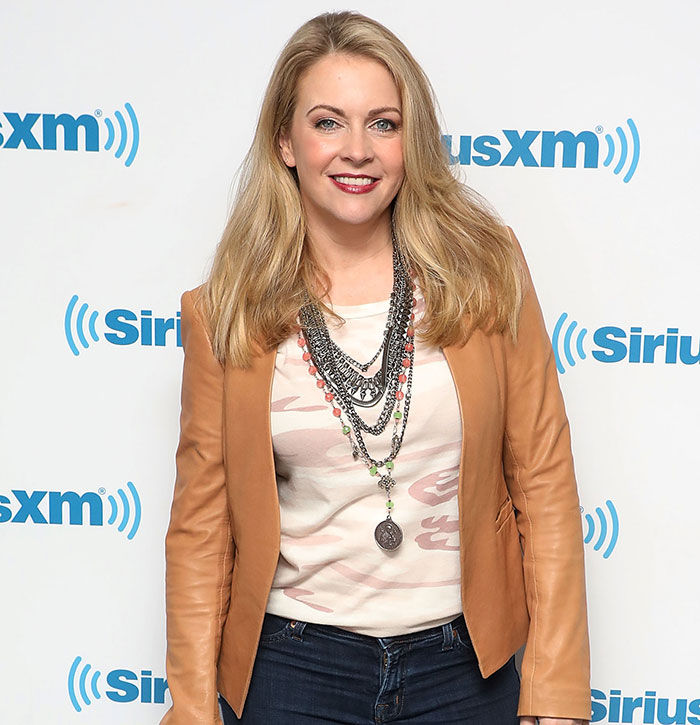 Blonde woman in a leather jacket poses at a SiriusXM event, smiling. Blonde woman in a leather jacket poses at a SiriusXM event, smiling.