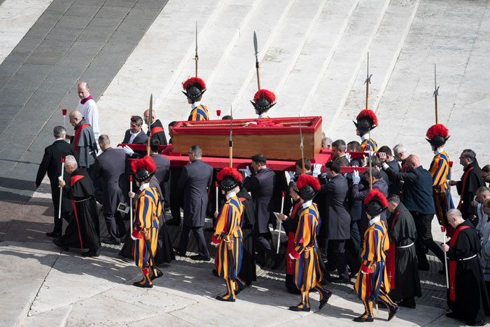 Pope Francis' open casket carried by guards in Vatican ceremony featuring Swiss Guards. Pope Francis' open casket carried by guards in Vatican ceremony featuring Swiss Guards.