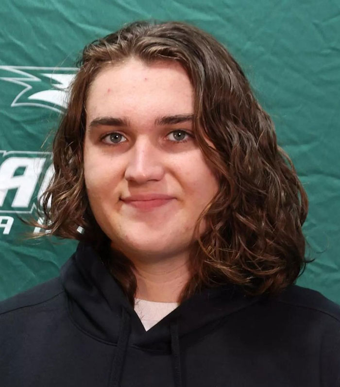 Unknown person with long hair in a black hoodie, standing in front of a green background. Unknown person with long hair in a black hoodie, standing in front of a green background.