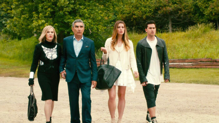Four people walking outdoors confidently, featuring main characters from a highly-rated TV show.