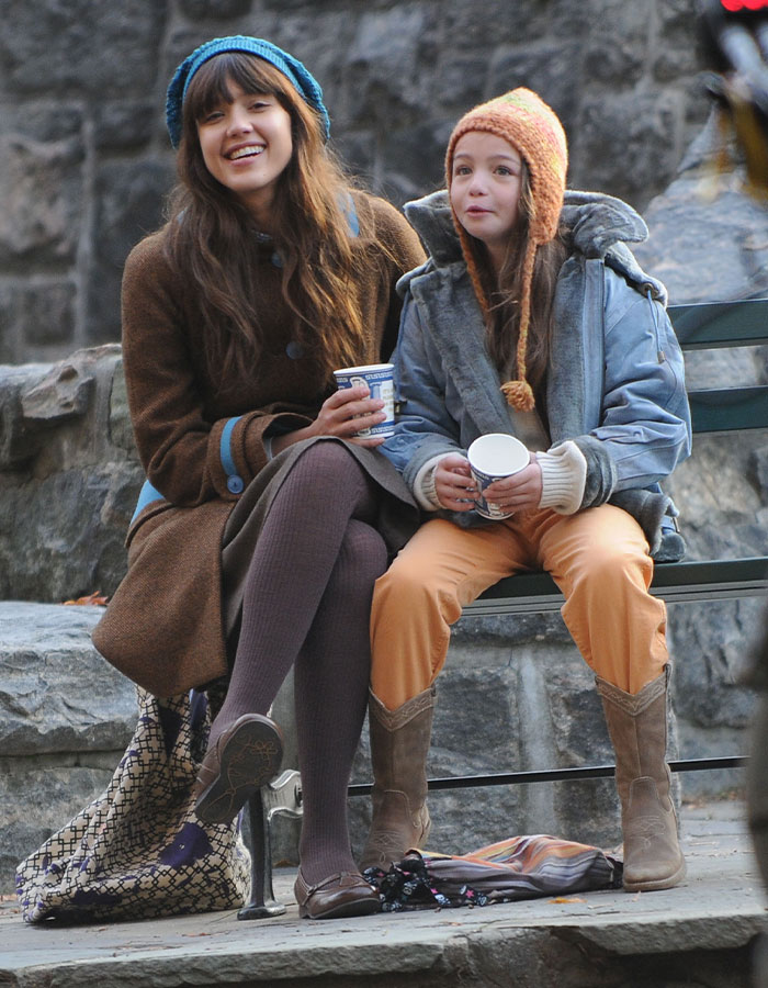 Two women on a bench in winter clothing, smiling and holding coffee cups, related to child star's mysterious passing. Two women on a bench in winter clothing, smiling and holding coffee cups, related to child star's mysterious passing.