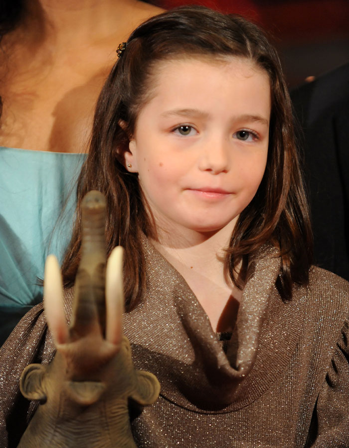 A former child star poses in a silver dress, holding a toy elephant, highlighting mystery of pregnancy revelation. A former child star poses in a silver dress, holding a toy elephant, highlighting mystery of pregnancy revelation.