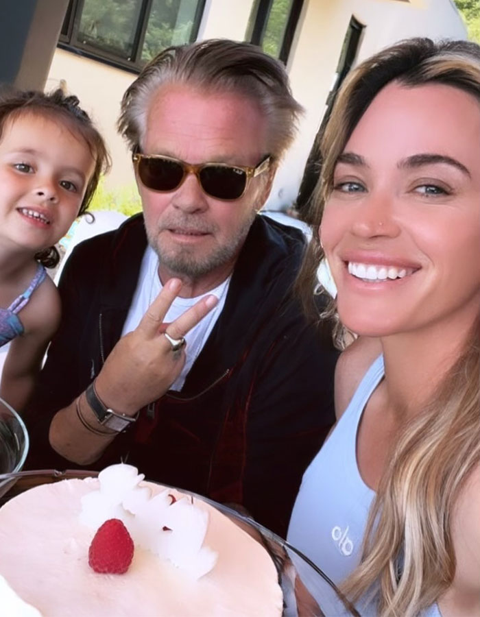 A smiling family moment with Teddi Mellencamp, her dad, and a child outdoors. A smiling family moment with Teddi Mellencamp, her dad, and a child outdoors.