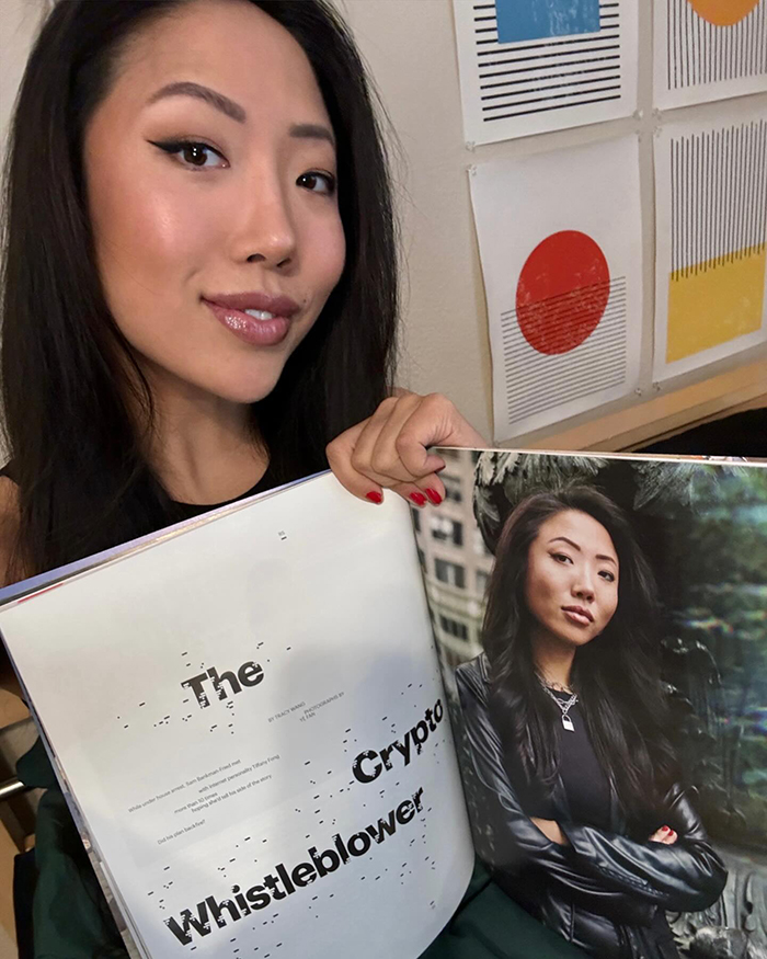 Woman holding a magazine featuring an article titled "The Crypto Whistleblower. Woman holding a magazine featuring an article titled "The Crypto Whistleblower.