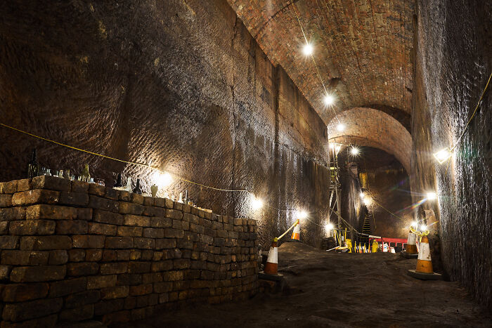 Underground city tunnel with brick walls and soft lighting, showcasing the eerie architecture found below ground.