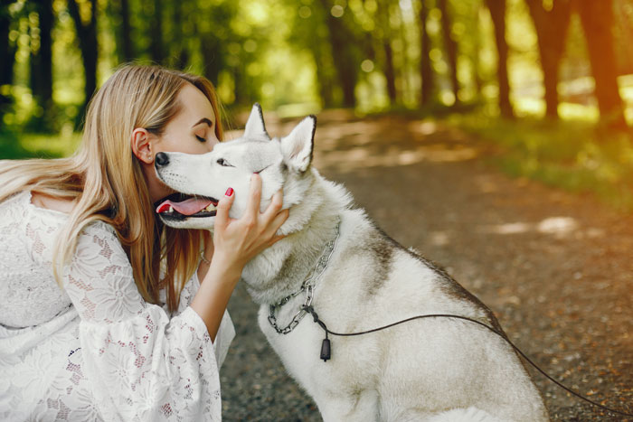 Woman hugging an adopted dog in a park, highlighting a spouse spat over the dog's behavior. Woman hugging an adopted dog in a park, highlighting a spouse spat over the dog's behavior.
