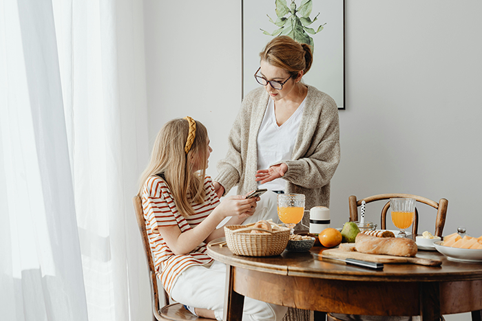 Woman and her fiancé's daughter at breakfast table, sharing a moment. Woman and her fiancé's daughter at breakfast table, sharing a moment.