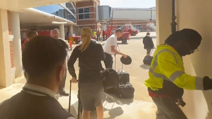 Delta passengers stranded on tarmac, handling luggage after flights rerouted by storms. Delta passengers stranded on tarmac, handling luggage after flights rerouted by storms.