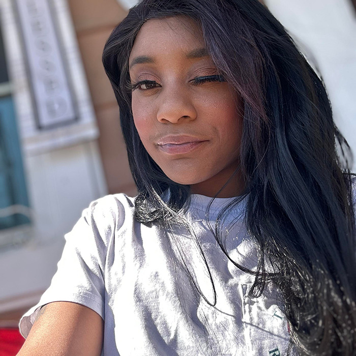 Black woman outdoors, wearing a gray shirt, in daylight. Black woman outdoors, wearing a gray shirt, in daylight.