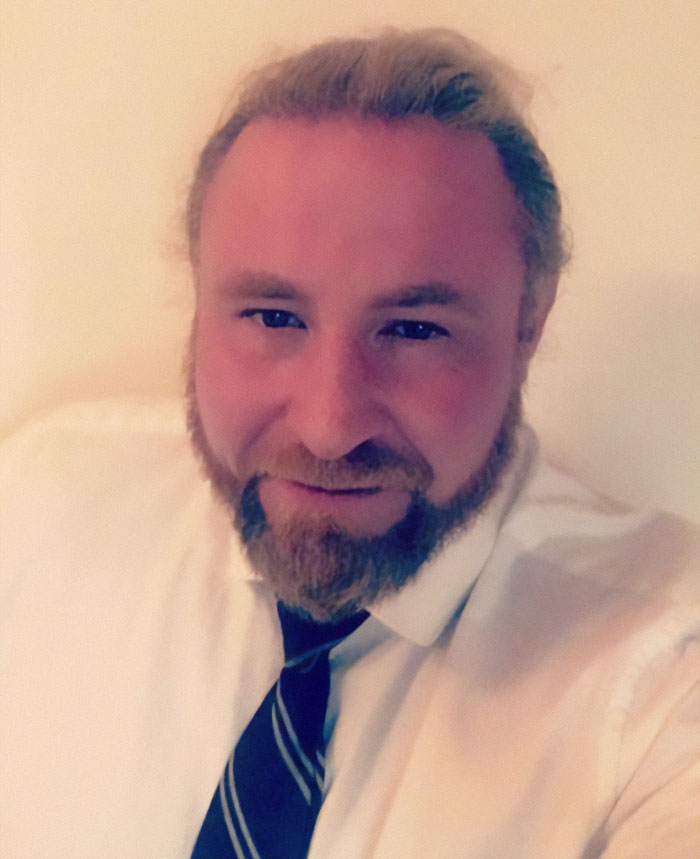 A man in white shirt and tie smiling, related to a family's burial mystery. A man in white shirt and tie smiling, related to a family's burial mystery.
