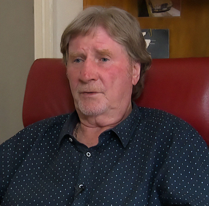 Man in a polka dot shirt sitting on a red chair, linked to a family mystery about burial location disclosure. Man in a polka dot shirt sitting on a red chair, linked to a family mystery about burial location disclosure.