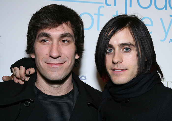 Two men in dark clothing at a public event. Two men in dark clothing at a public event.
