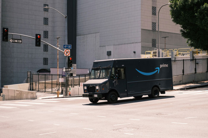 Amazon delivery truck driving on city street, related to heroic delivery driver incident. Amazon delivery truck driving on city street, related to heroic delivery driver incident.