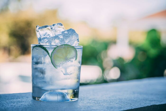 A glass with ice cubes and lime, a common indicator of an American tourist's drink preference.