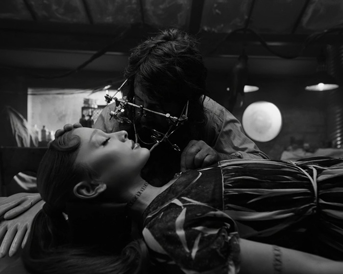 Ariana Grande shown with tattoos and hair transformation in a dramatic black-and-white setting. Ariana Grande shown with tattoos and hair transformation in a dramatic black-and-white setting.