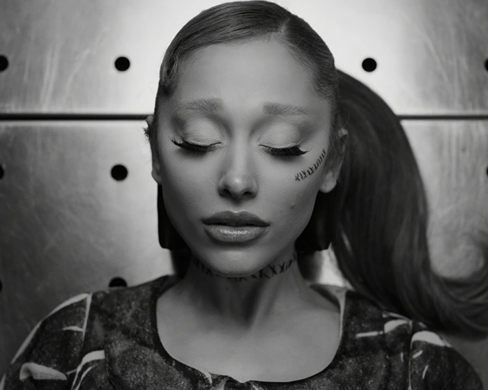 A person showcases tattoos and a hair transformation in a black-and-white portrait. A person showcases tattoos and a hair transformation in a black-and-white portrait.