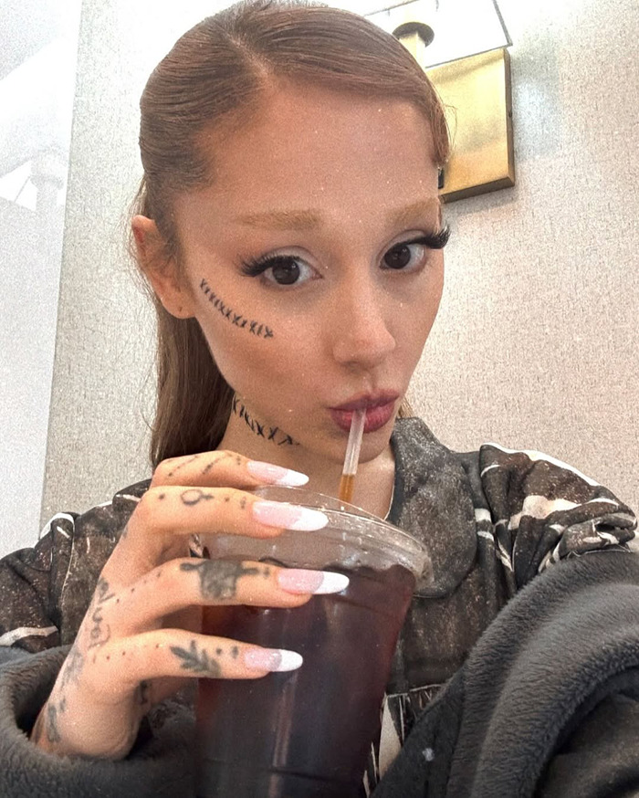 Ariana Grande with new hair and tattoos, sipping a drink, showing her latest transformation. Ariana Grande with new hair and tattoos, sipping a drink, showing her latest transformation.