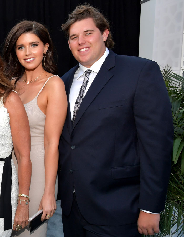 Man in a suit with impressive weight loss standing next to a woman in a beige dress. Man in a suit with impressive weight loss standing next to a woman in a beige dress.