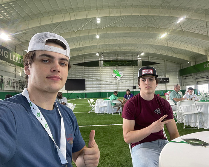 Two young men wearing hats in a sports venue amid Austin Metcalf conspiracy context. Two young men wearing hats in a sports venue amid Austin Metcalf conspiracy context.