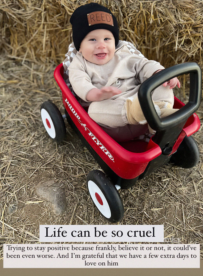 Toddler smiling in a red wagon, wearing a black hat. Toddler smiling in a red wagon, wearing a black hat.