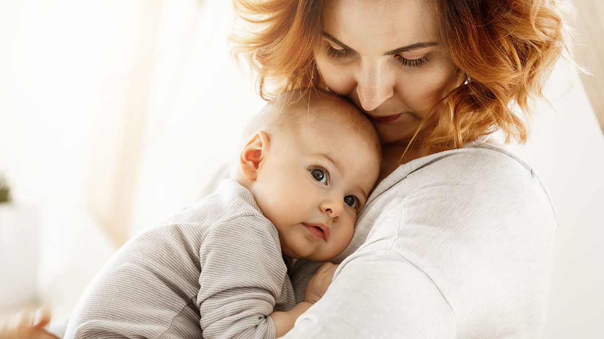 Woman holding newborn baby close while showing concern about babysitting payment fairness and refusal.