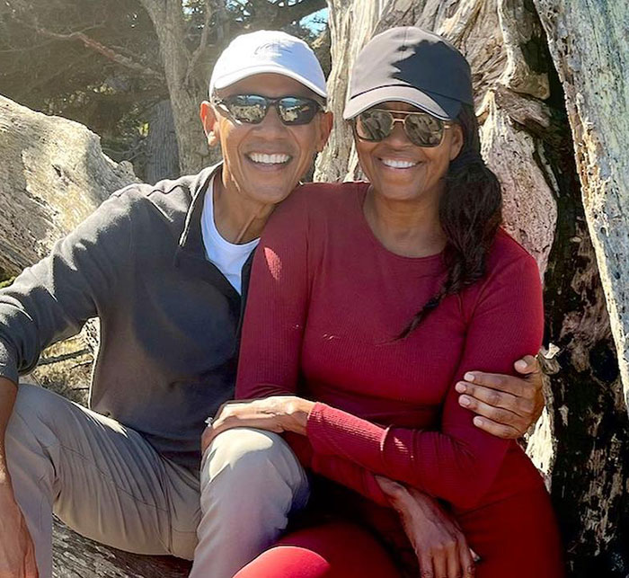 Michelle Obama smiling outdoors, wearing sunglasses, addressing divorce rumors. Michelle Obama smiling outdoors, wearing sunglasses, addressing divorce rumors.