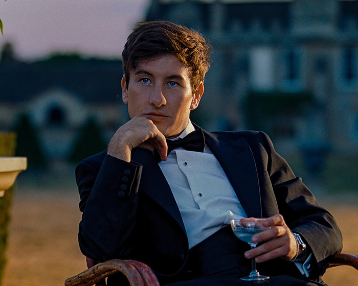 Man in formal attire sitting outdoors, raising questions about casting choices in Beatles biopic. Man in formal attire sitting outdoors, raising questions about casting choices in Beatles biopic.