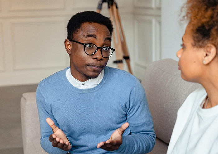 Man in blue sweater talking to woman, discussing wedding bet situation. Man in blue sweater talking to woman, discussing wedding bet situation.
