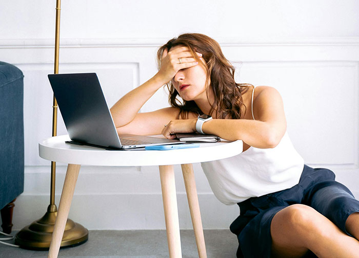 Woman feeling trapped at home, stressed by boyfriend challenging her medical expertise, sitting by a laptop. Woman feeling trapped at home, stressed by boyfriend challenging her medical expertise, sitting by a laptop.