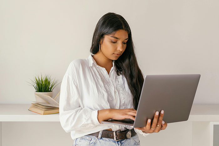 Woman using laptop at home office, contemplating medical expertise. Woman using laptop at home office, contemplating medical expertise.